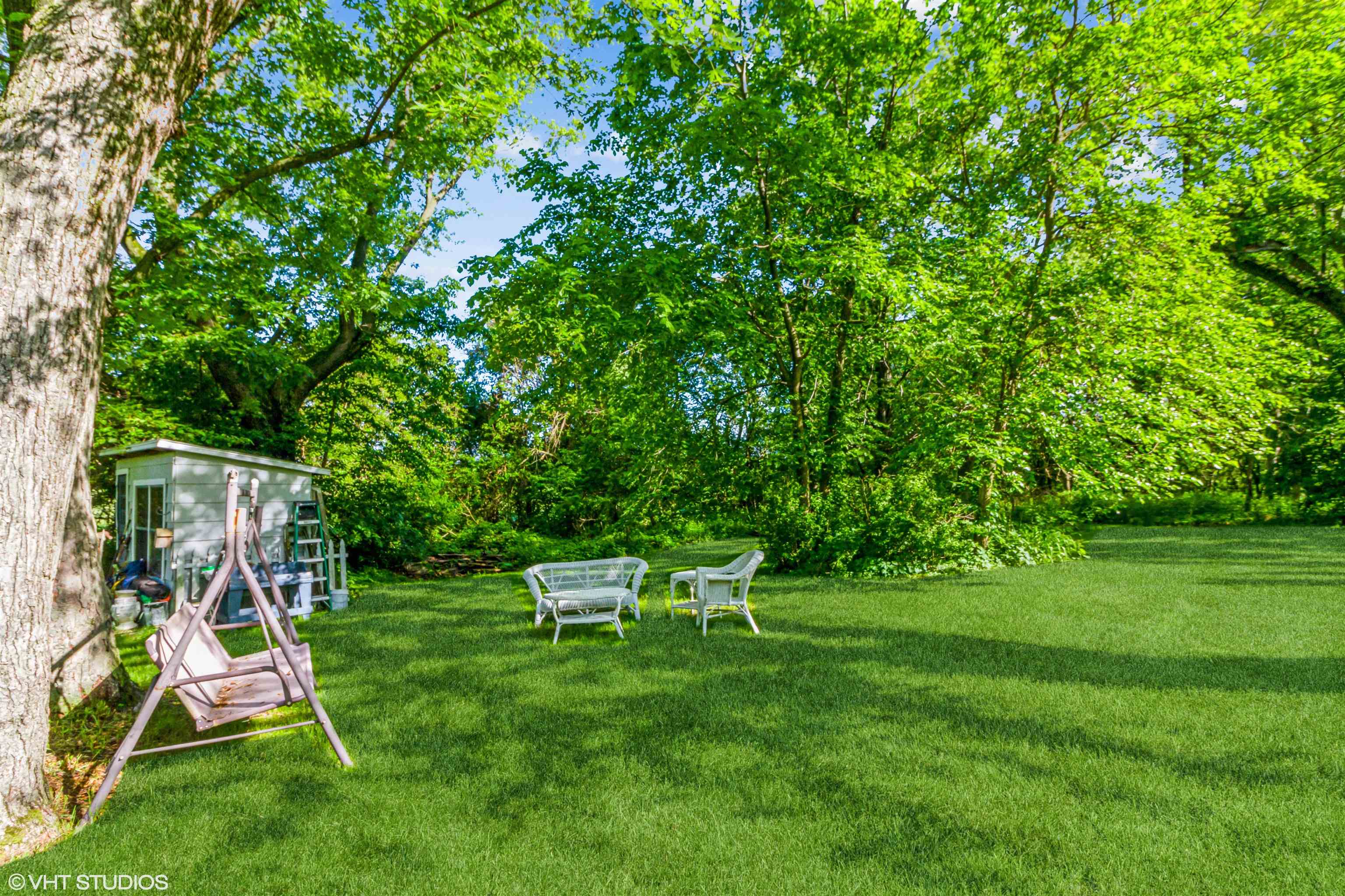 8036 South Avon Store Road Brodhead, WI 53520 - Photo 19 of 20 a view of a backyard with a slide trees and wooden fence