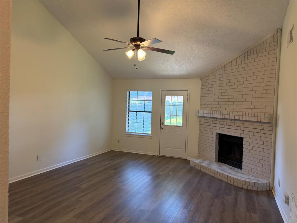 112 Cinnamon Lane Euless, TX 76039 - Photo 2 of 12 an empty room with wooden floor fireplace and windows