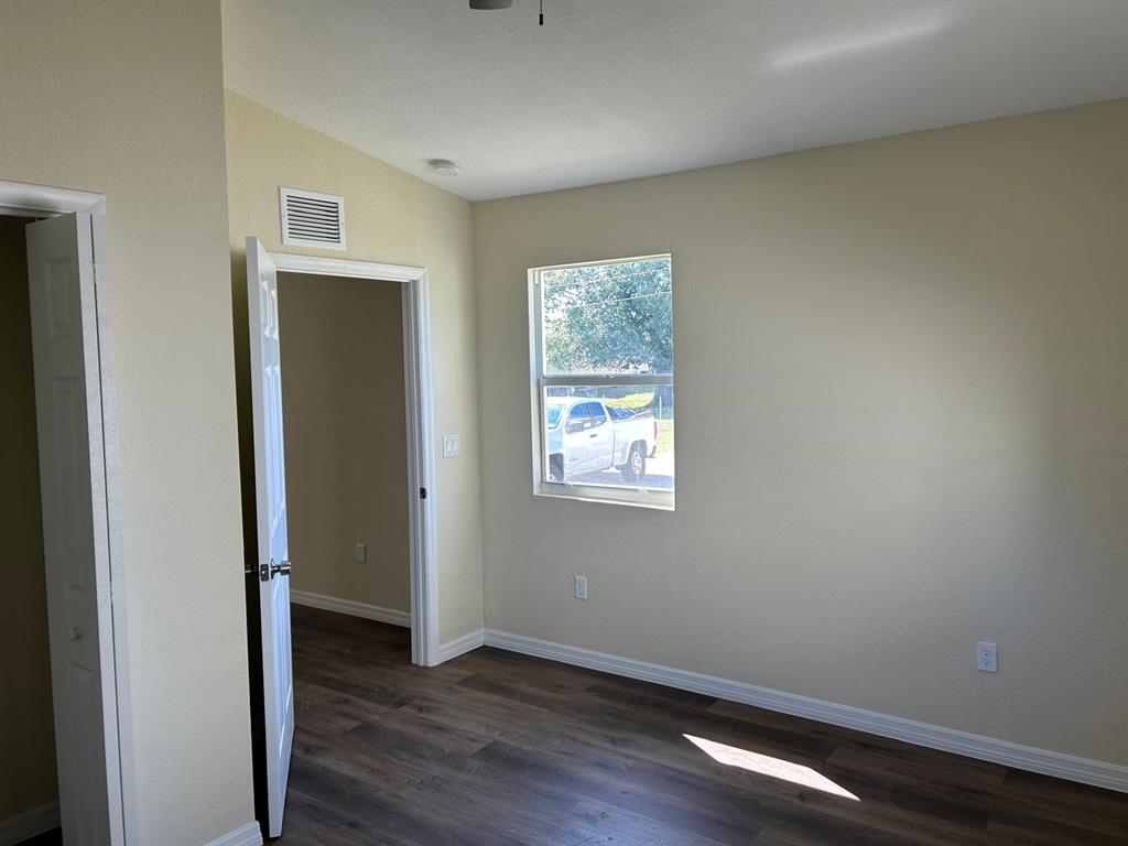 371 Banyan Avenue Pahokee, FL 33476 - Photo 14 of 17 a view of an empty room with wooden floor and a window