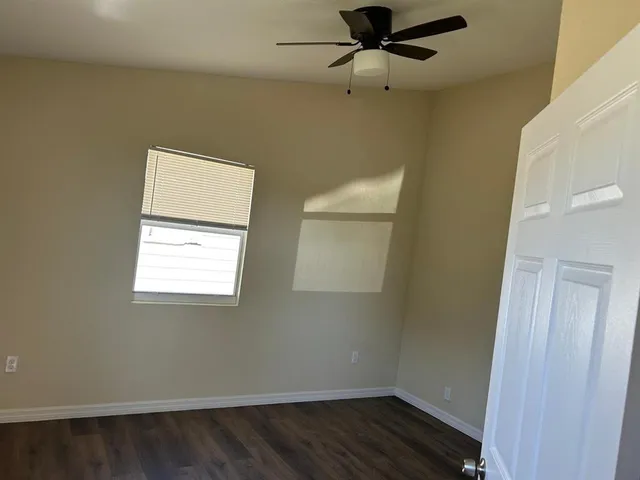 an empty room with a window and wooden floor