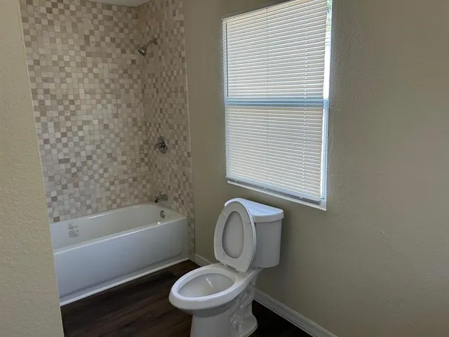 a white toilet sitting next to a bath tub