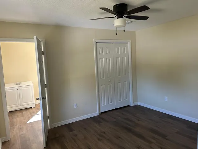a view of a livingroom with wooden floor and a ceiling fan