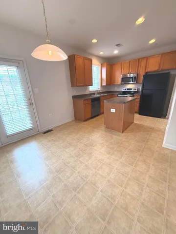 a kitchen with stainless steel appliances granite countertop a sink a stove and a refrigerator