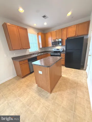 a kitchen with stainless steel appliances a stove a sink and a refrigerator