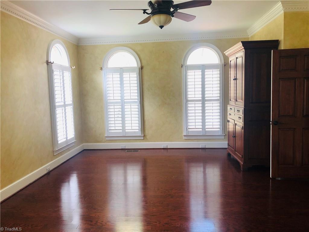 150 Jd Essick Road Lexington, NC 27295 - Photo 25 of 49 Primary bedroom on main level boasts arched windows and lovely heavy moldings