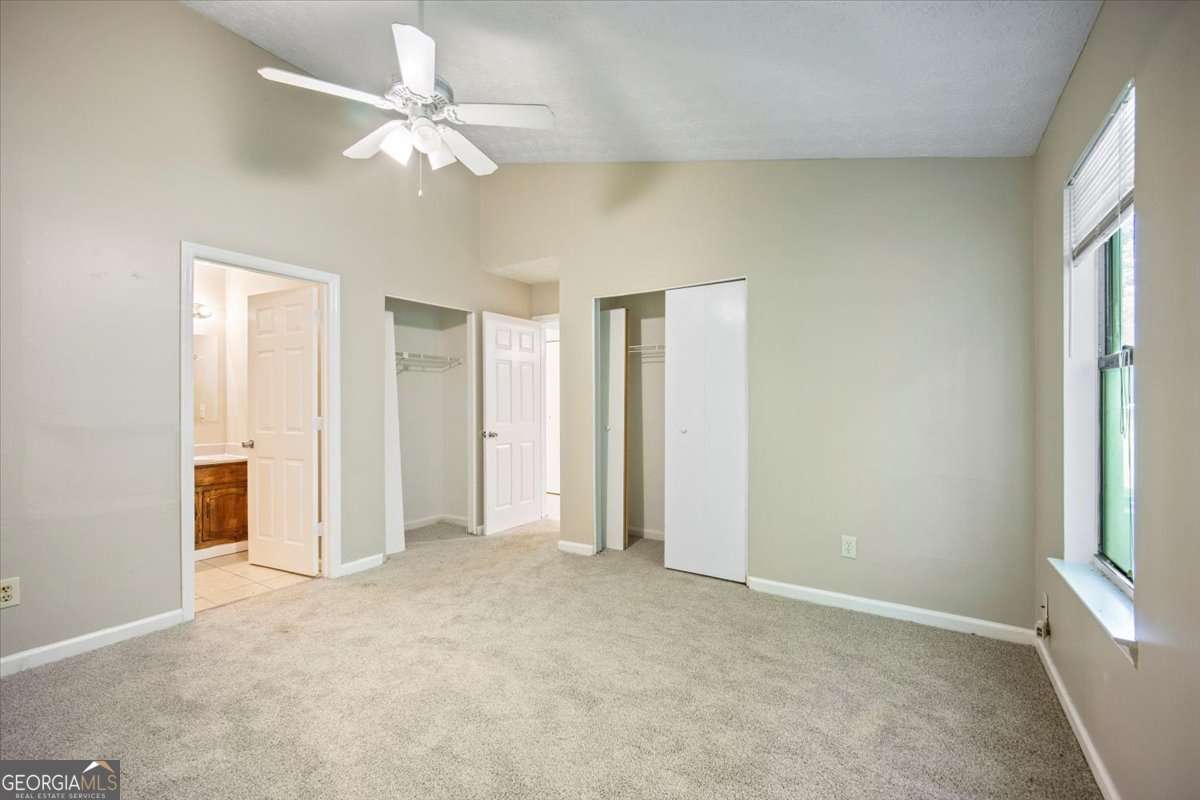 5426 Martins Crossing Road Stone Mountain, GA 30088 - Photo 14 of 26 an empty room with a ceiling fan and a window