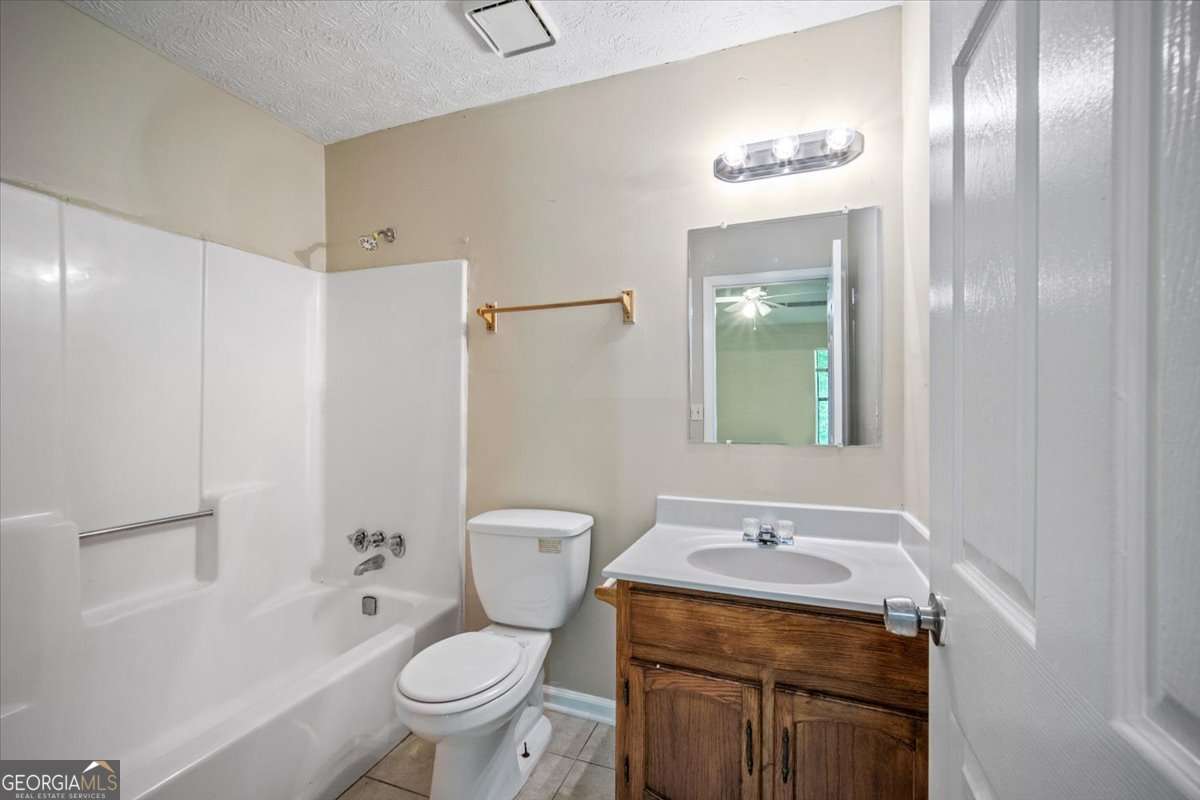 5426 Martins Crossing Road Stone Mountain, GA 30088 - Photo 19 of 26 a bathroom with a granite countertop sink toilet and shower