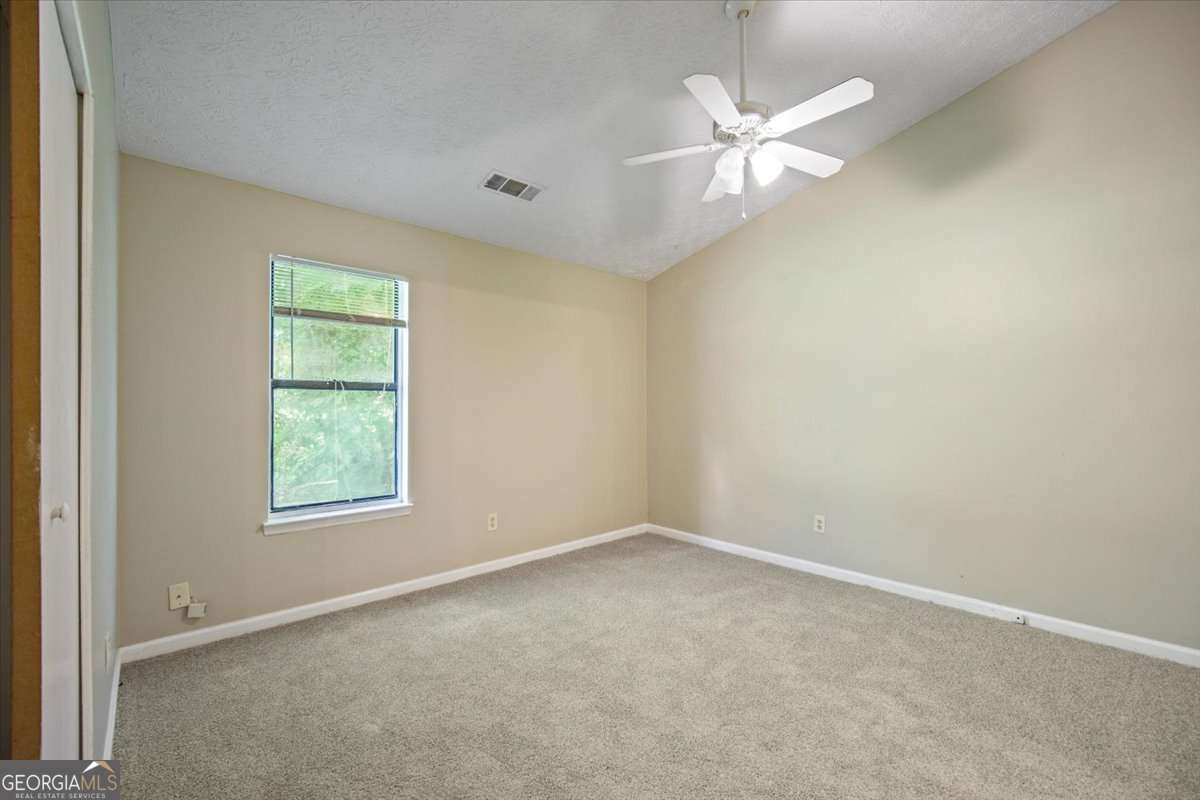 5426 Martins Crossing Road Stone Mountain, GA 30088 - Photo 20 of 26 an empty room with a window and a fan