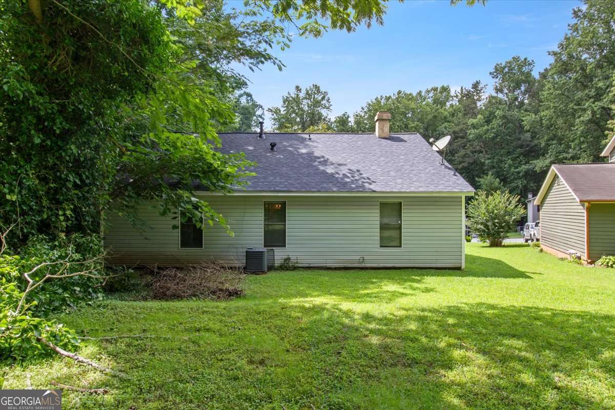 5426 Martins Crossing Road Stone Mountain, GA 30088 - Photo 24 of 26 a view of a house with a yard and a large tree