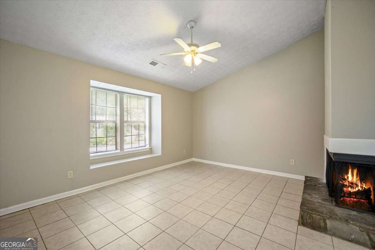 5426 Martins Crossing Road Stone Mountain, GA 30088 - Photo 6 of 26 an empty room with windows and fireplace