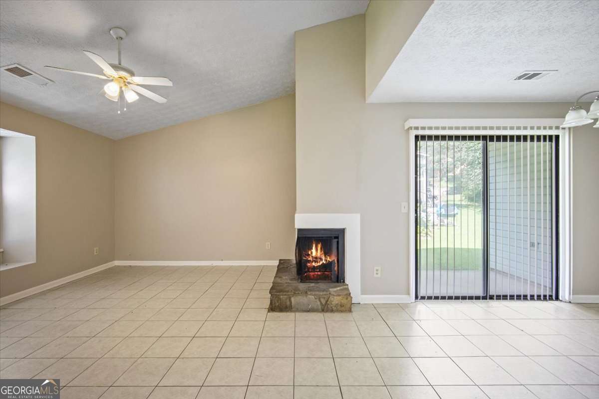 5426 Martins Crossing Road Stone Mountain, GA 30088 - Photo 7 of 26 an empty room with fan and windows
