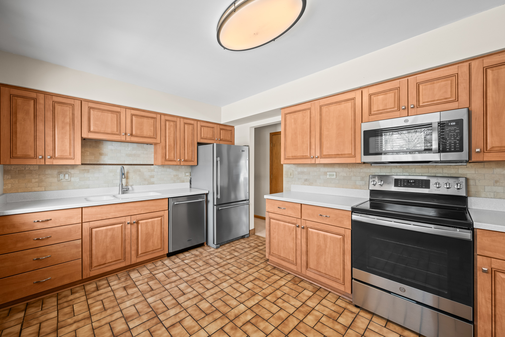 496 Raupp Boulevard Buffalo Grove, IL 60089 - Photo 5 of 19 a kitchen with stainless steel appliances granite countertop a stove top oven a sink dishwasher and a microwave oven on the blue kitchen countertops