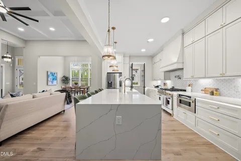 a kitchen with kitchen island a stove a table and chairs