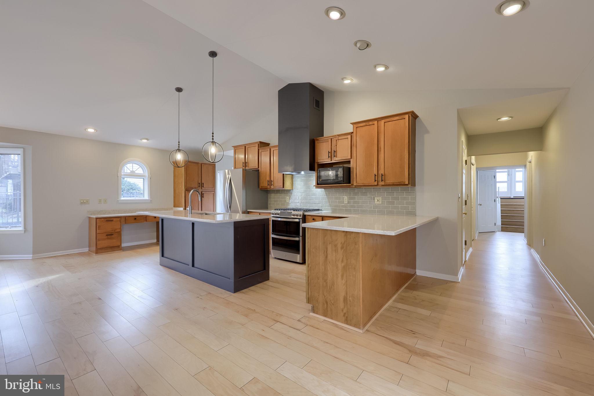 421 Longmeadow Road Lancaster, PA 17601 - Photo 4 of 44 a large kitchen with stainless steel appliances kitchen island granite countertop a large counter top and wooden floors