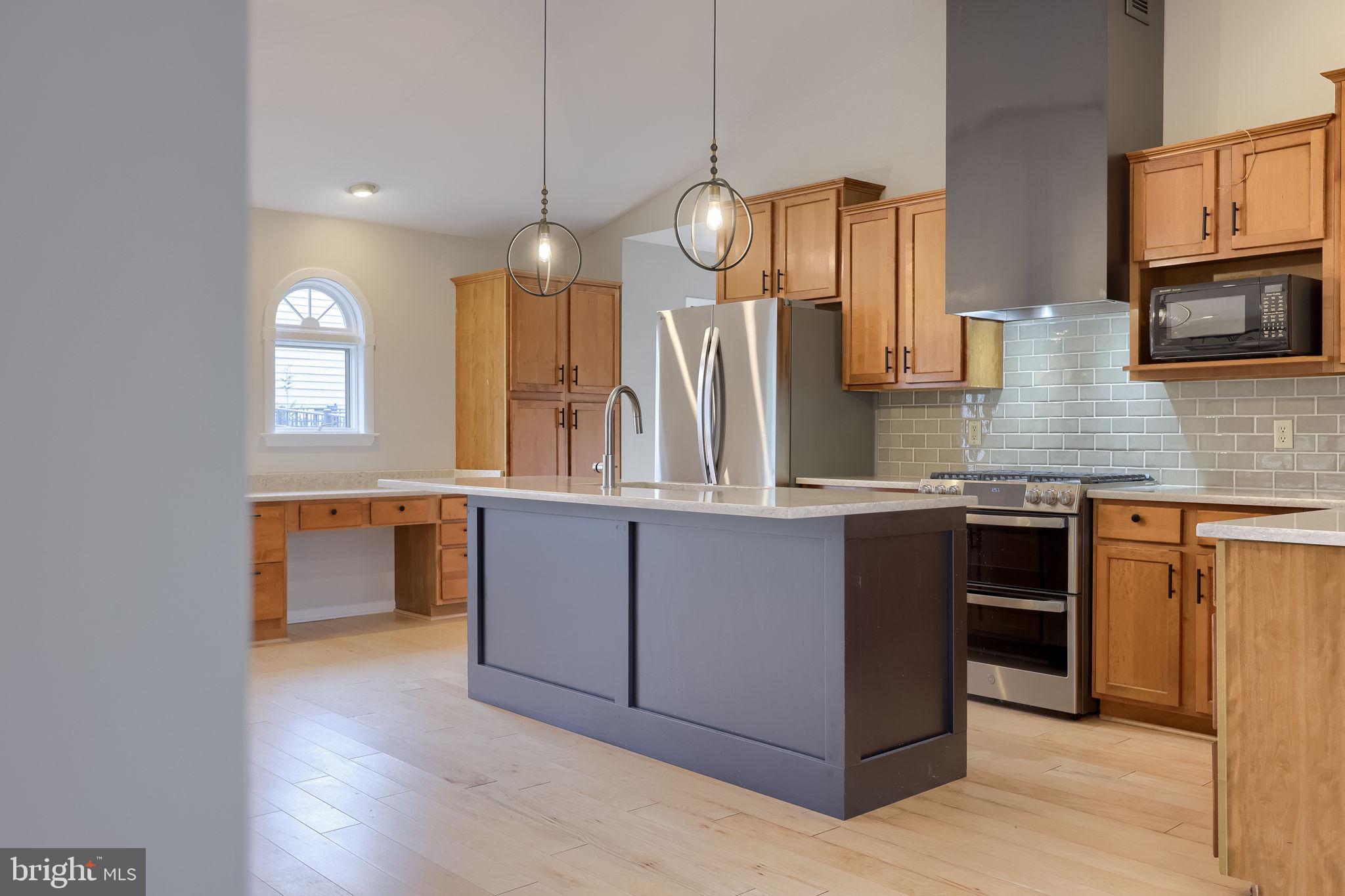 421 Longmeadow Road Lancaster, PA 17601 - Photo 9 of 44 a kitchen with kitchen island granite countertop a stove a sink a center island and wooden floor
