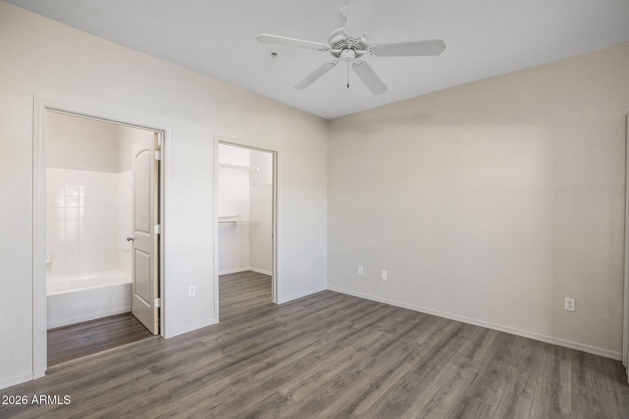 4644 North 22nd Street, Unit 1017 Phoenix, AZ 85016 - Photo 4 of 17 an empty room with wooden floor and a ceiling fan