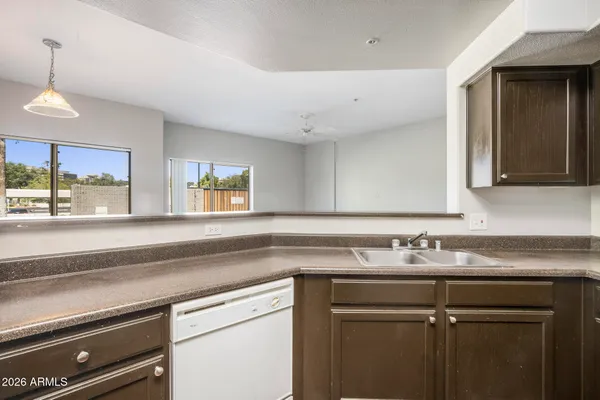 a view of a kitchen sink a microwave and cabinets