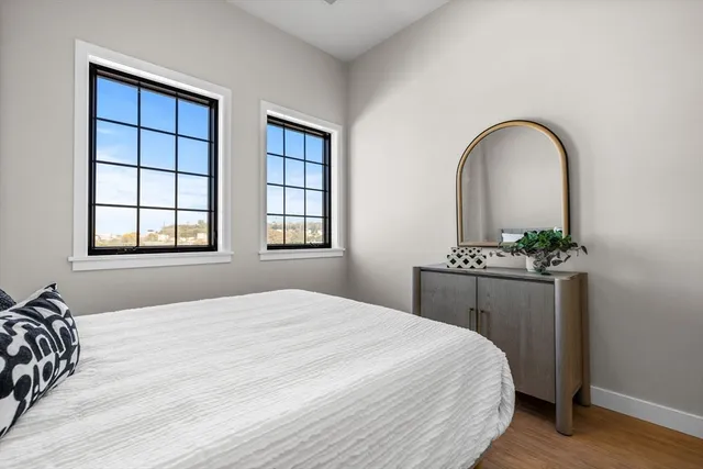 a bedroom with a bed and a potted plant next to a window