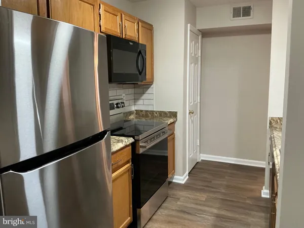 a kitchen with a stove and a wooden floor