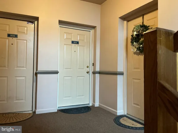 an empty room with wooden floor fireplace and windows