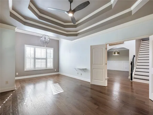 a view of a livingroom with wooden floor and a ceiling fan