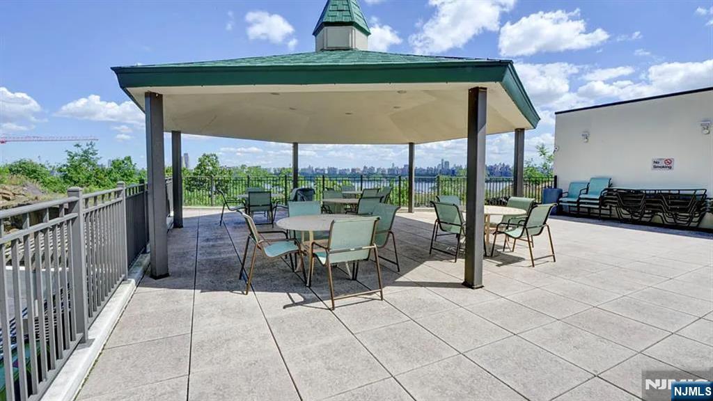 250 Gorge Road, Unit 17L Cliffside Park, NJ 07010 - Photo 20 of 30 a view of a patio with a table and chairs under an umbrella