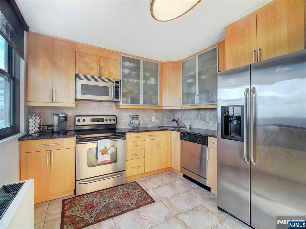 250 Gorge Road, Unit 17L Cliffside Park, NJ 07010 - Photo 5 of 30 a kitchen with stainless steel appliances granite countertop a stove a sink and a microwave