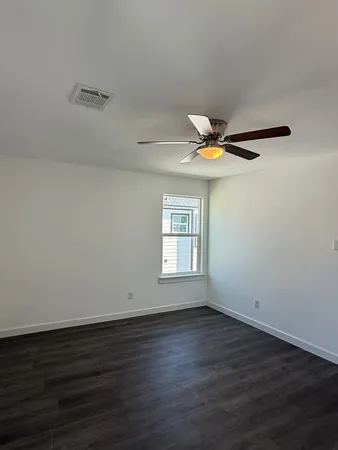 a view of wooden floor and a chandelier fan in a room