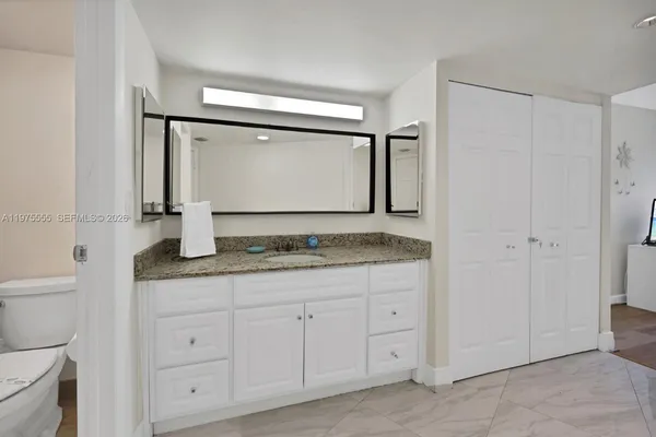 a bathroom with a granite countertop sink and a mirror