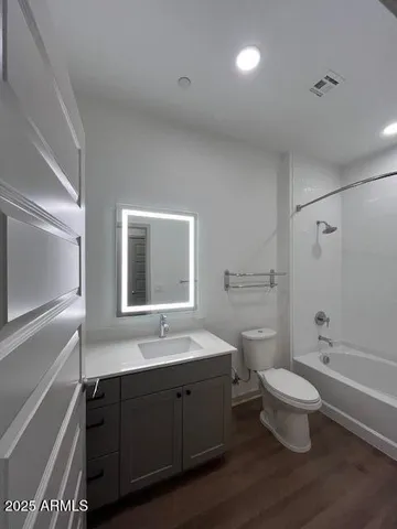 a bathroom with a double vanity sink toilet mirror and shower