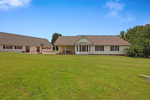 a front view of house with yard and trees in the background