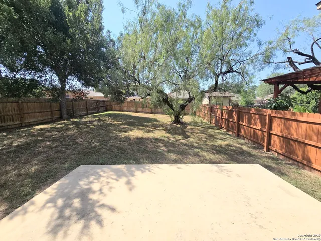 a view of a yard with wooden fence