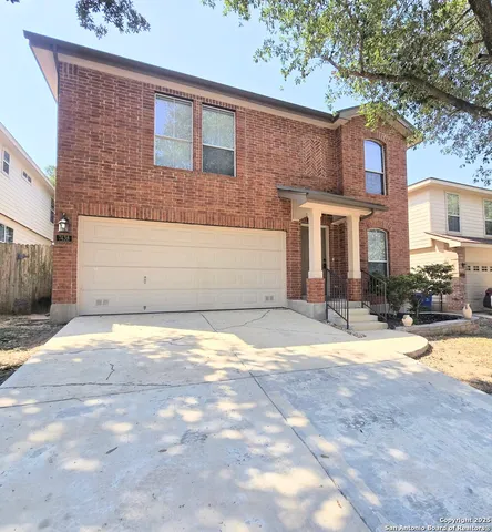 a view of a house with a yard and a tree