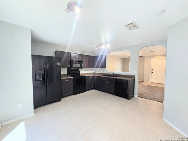 a kitchen with granite countertop a refrigerator and a sink