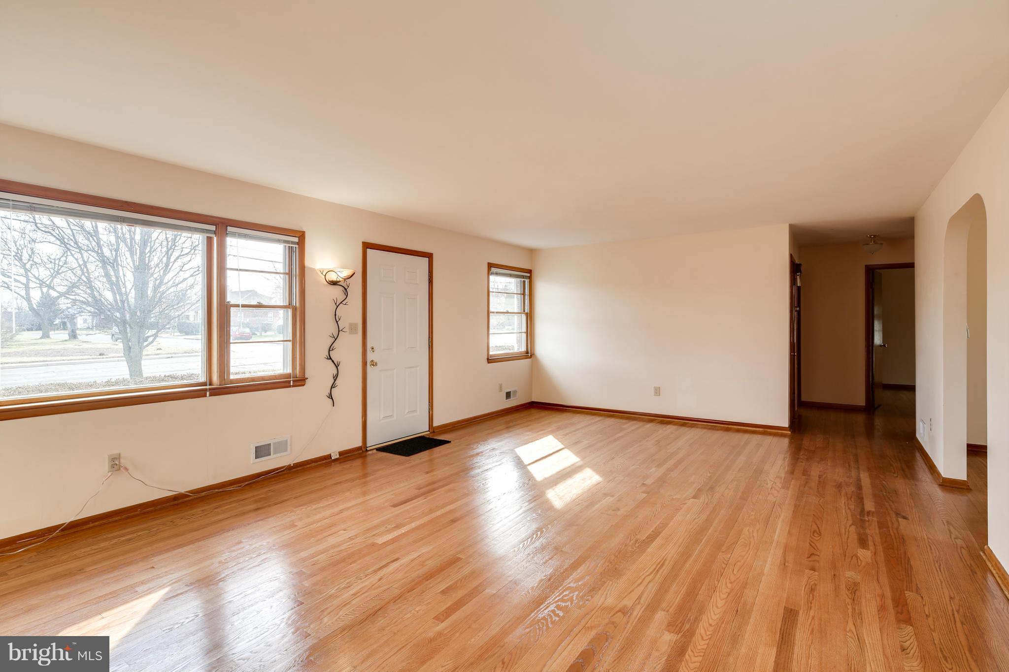 700 East Maple Road Linthicum, MD 21090 - Photo 3 of 29 an empty room with wooden floor and windows