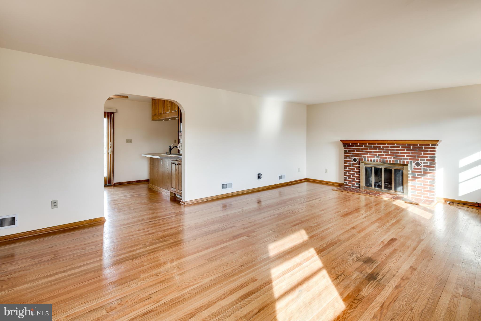 700 East Maple Road Linthicum, MD 21090 - Photo 4 of 29 an empty room with wooden floor and fireplace