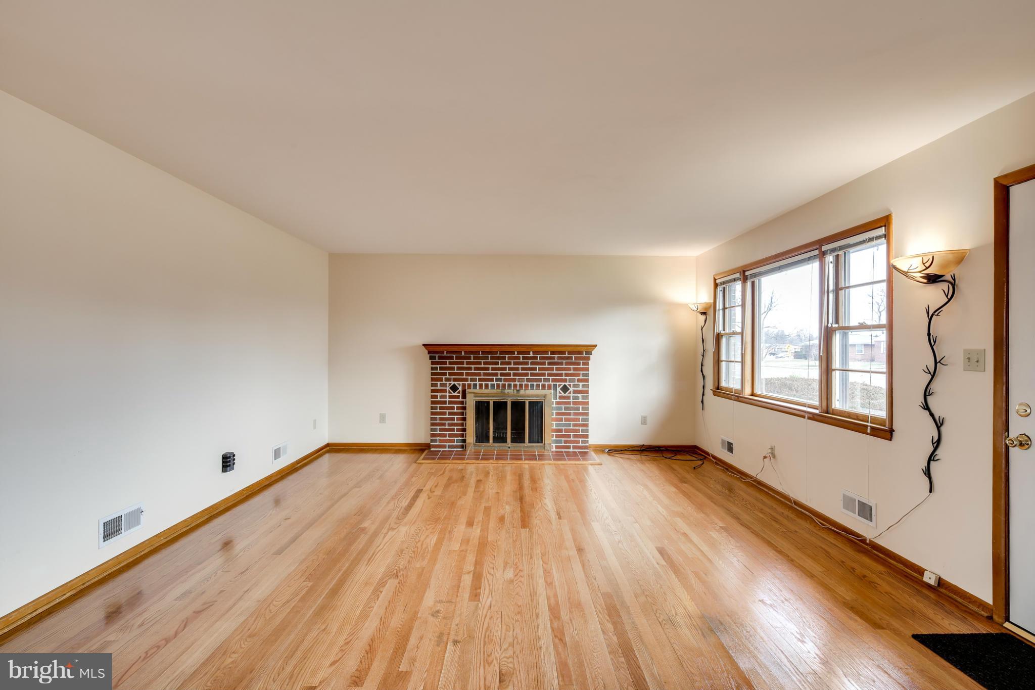700 East Maple Road Linthicum, MD 21090 - Photo 5 of 29 wooden floor fireplace and windows in an empty room
