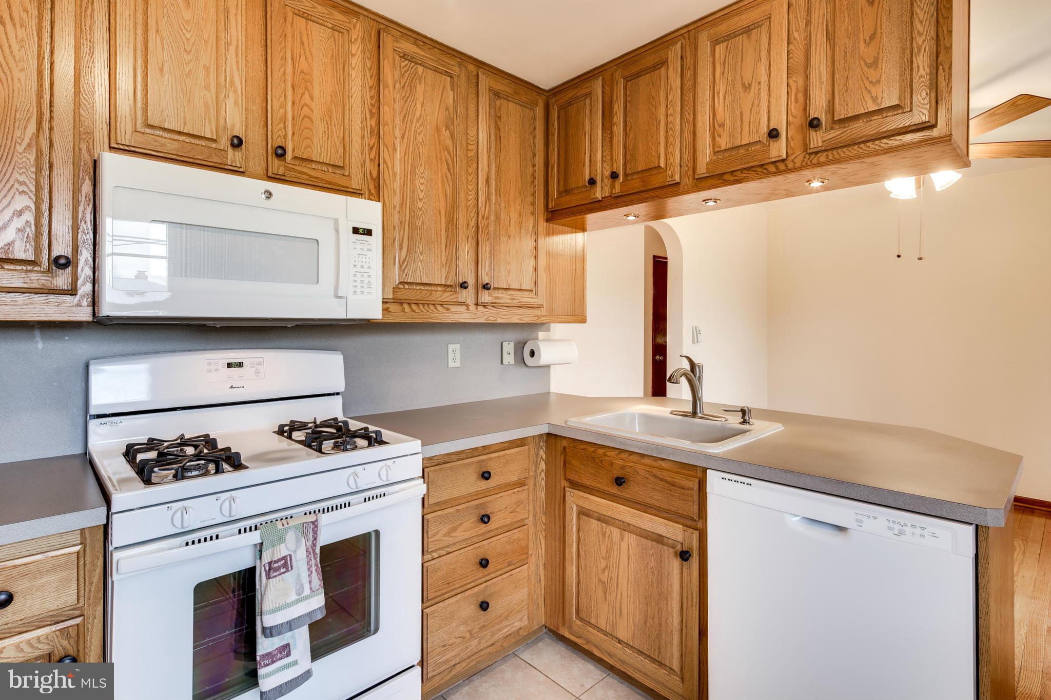 700 East Maple Road Linthicum, MD 21090 - Photo 10 of 29 a kitchen with granite countertop a stove sink and cabinets