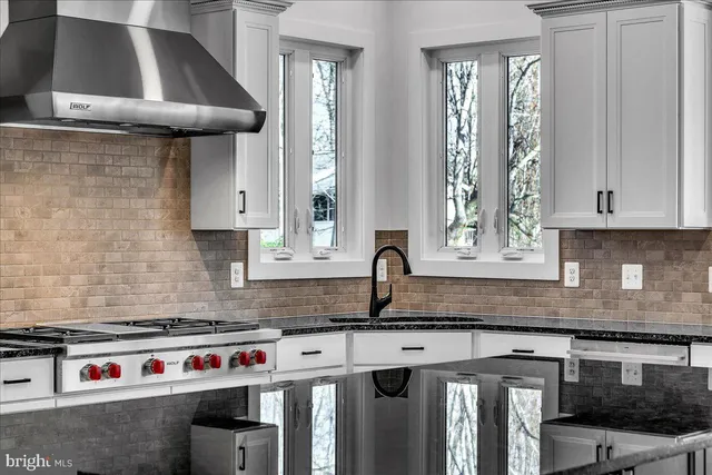 a kitchen with stainless steel appliances granite countertop a stove and a refrigerator