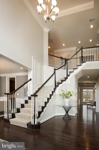 a large kitchen with cabinets chairs and wooden floor