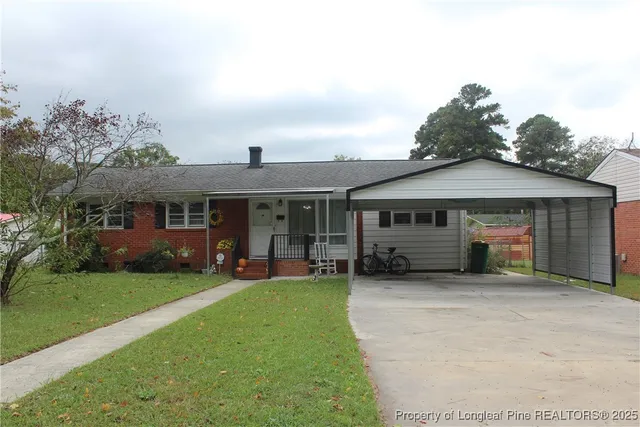 a front view of a house with a garden and trees
