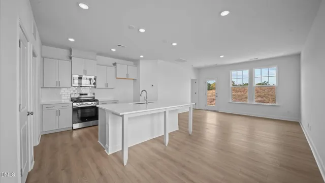 a kitchen with granite countertop white cabinets and stainless steel appliances