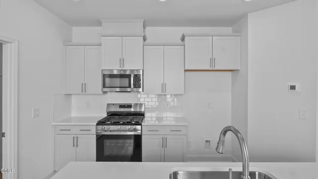 a kitchen with granite countertop white cabinets stainless steel appliances and sink