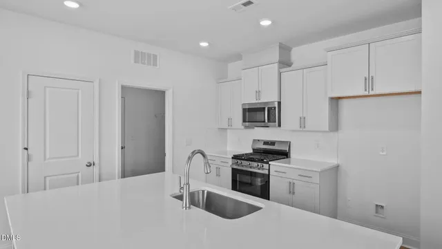 a kitchen with stainless steel appliances granite countertop a refrigerator and a stove top oven