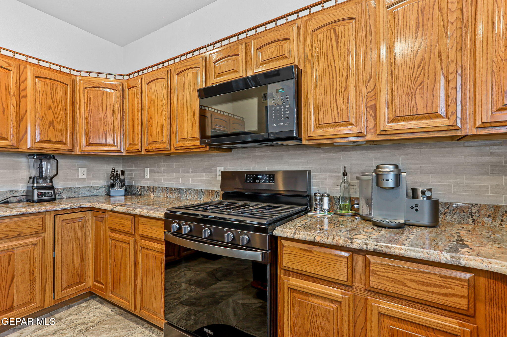 6544 Royal Ridge Drive El Paso, TX 79912 - Photo 19 of 58 a kitchen with stainless steel appliances granite countertop a stove a sink and a microwave