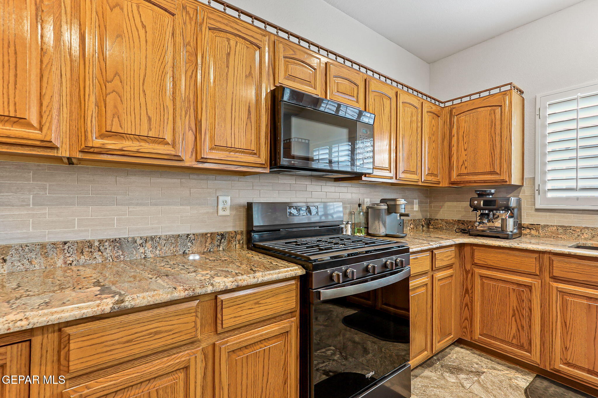 6544 Royal Ridge Drive El Paso, TX 79912 - Photo 21 of 58 a kitchen with stainless steel appliances granite countertop a stove a sink and a microwave