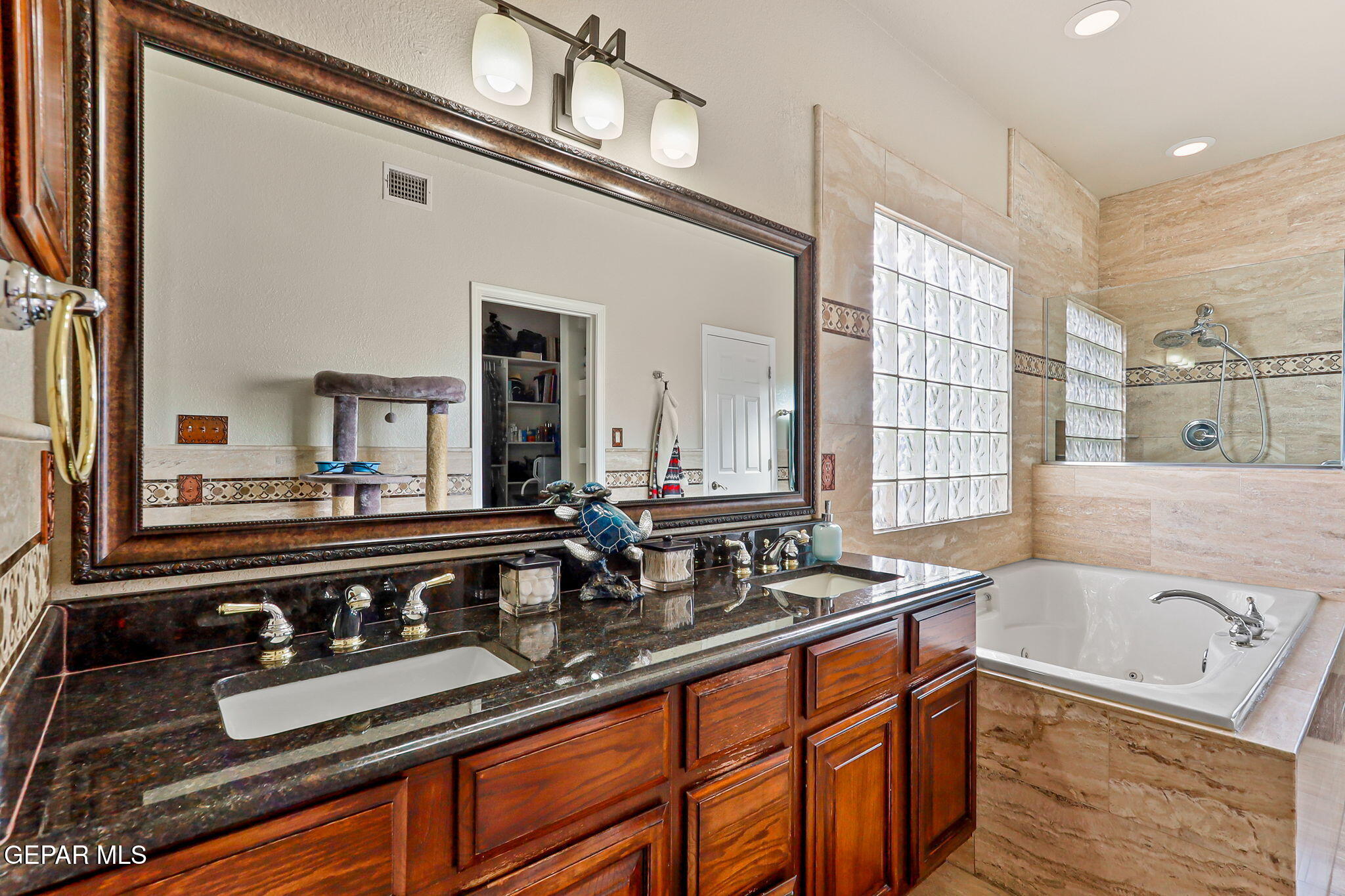 6544 Royal Ridge Drive El Paso, TX 79912 - Photo 34 of 58 a bathroom with a granite countertop sink a large mirror and bathtub