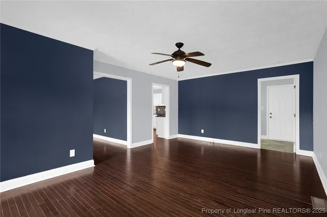 a view of an empty room with wooden floor