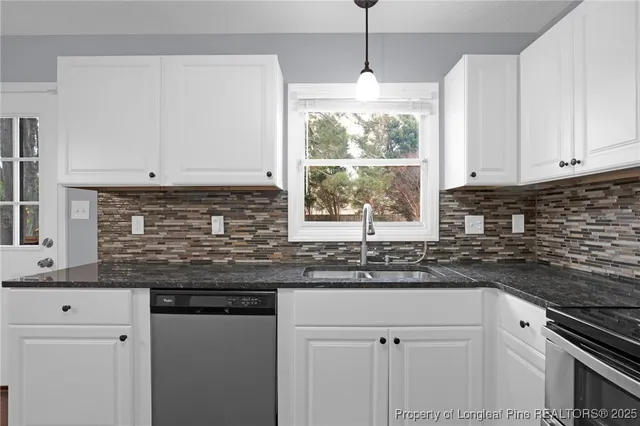 a kitchen with granite countertop white cabinets and white stainless steel appliances