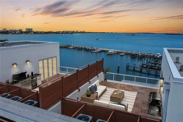 a view of a balcony with two chairs and a barbeque